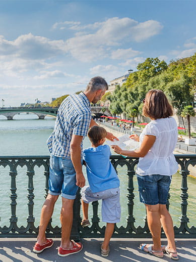Family of three on bridge in Paris, France