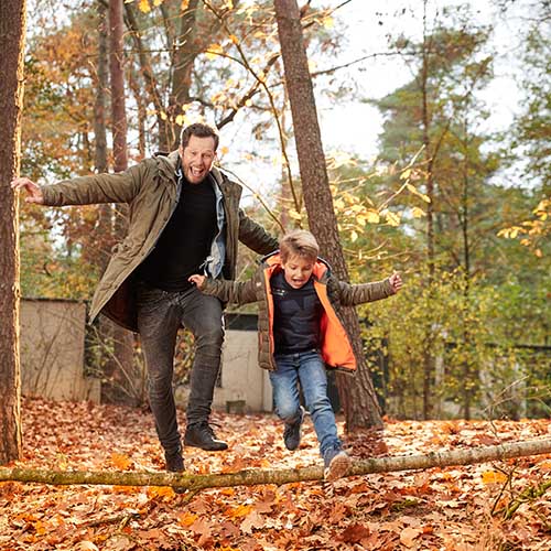 Father and son in autumnal forest at Center Parcs