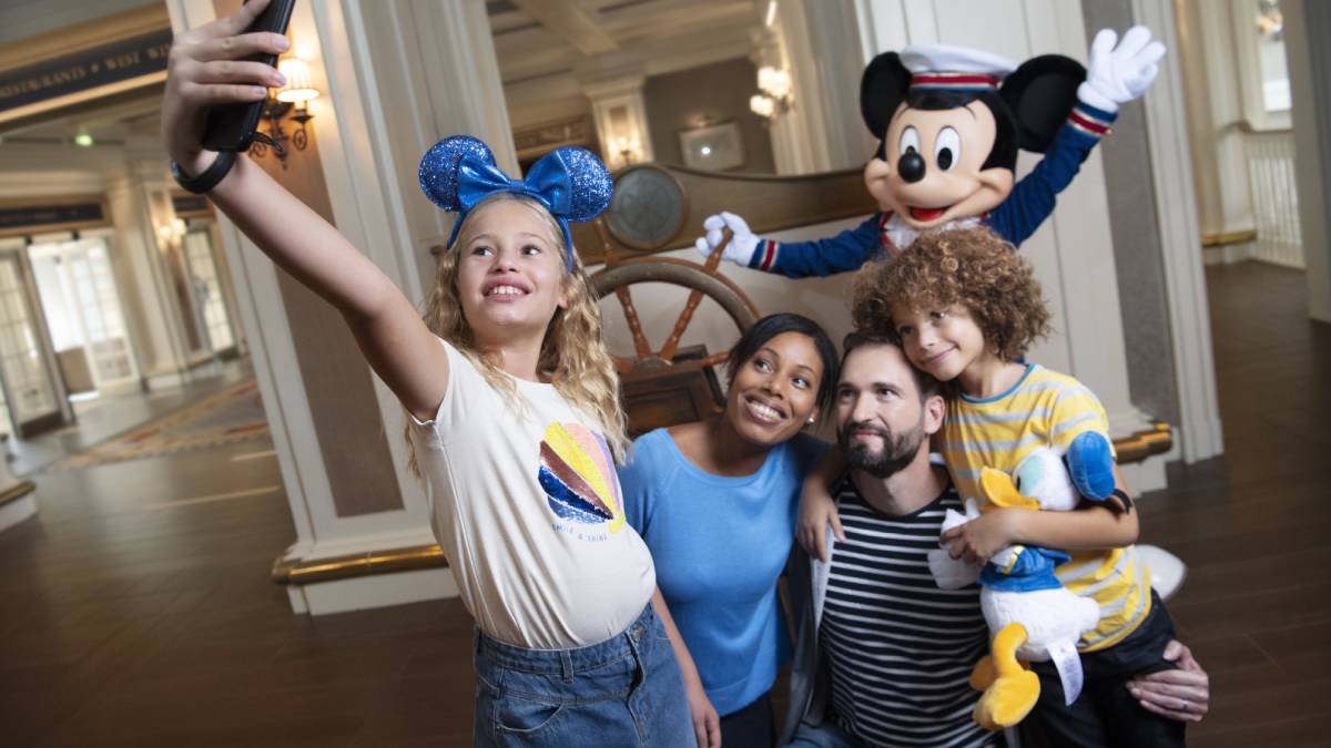 Family taking a selfie photo with Mickey at Disneyland Paris