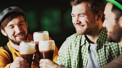 Irish pub - drie mannen die pinten bier drinken in een bar
