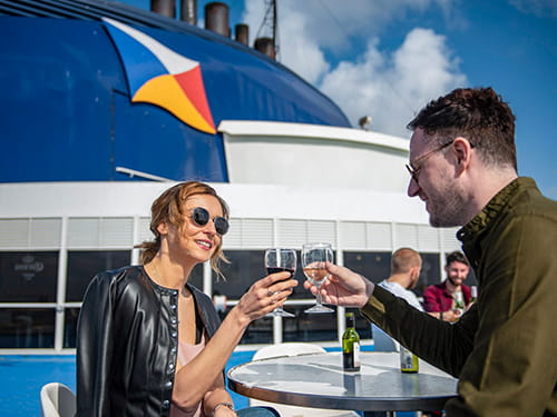 Koppel genietend van een drankje op het zonnedek van P&O Ferries