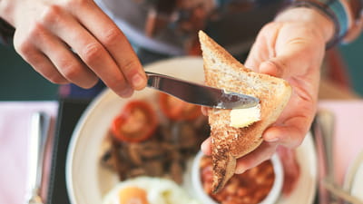 Hala gastronomiczna – ciepłe śniadanie i osoba smarująca tosta