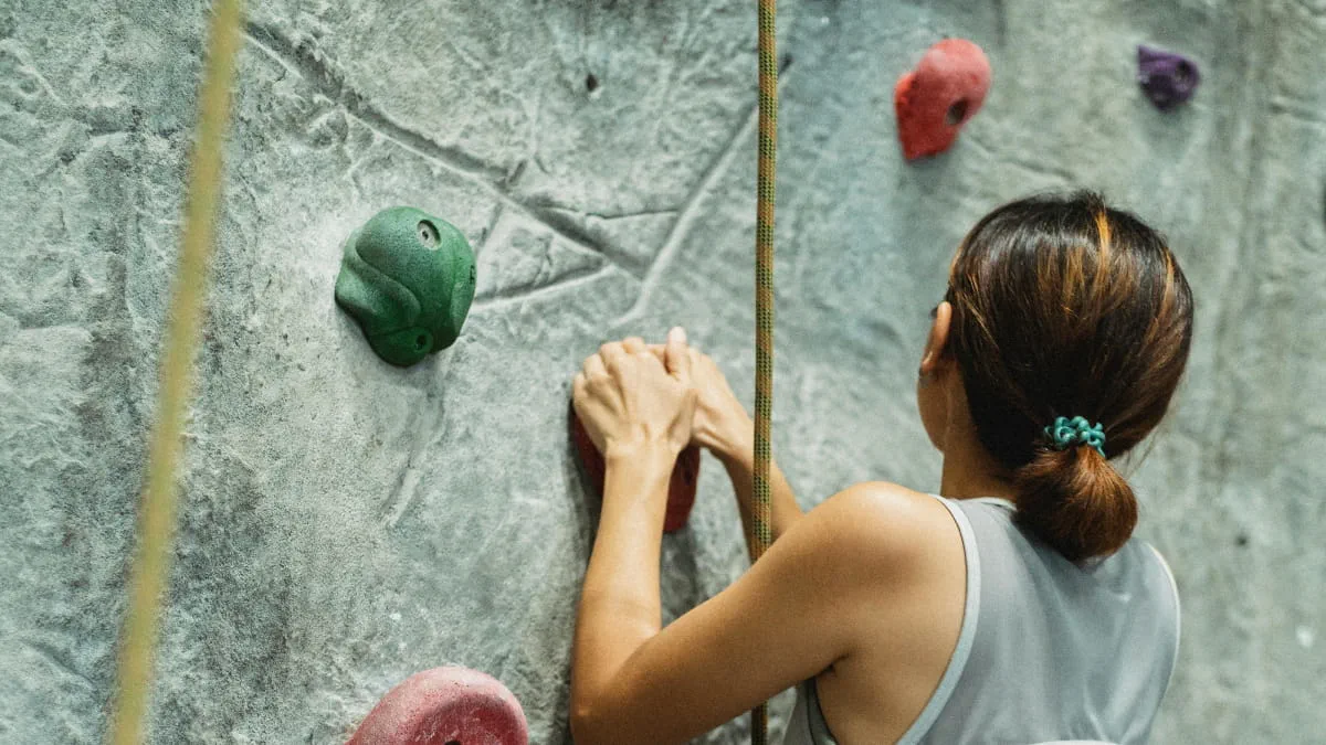 woman climbing wall in competition