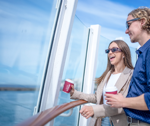 Couple on ferry deck with coffee